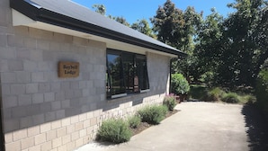 A building with a sign reading "Baybell Lodge." - Peaceful Orchard Cottage (Omanawa)