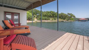 Une terrasse couverte avec des sièges et une vue sur un lac.