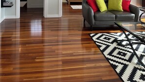 Un salon moderne avec un canapé en cuir, un tapis à motifs et un luminaire sphérique original.