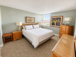 A bedroom with a bed, bedside tables, a dresser, and artwork on the walls. - Futura Yacht Club Islamorada Condo – Heated Pool, Marina & Deeded Slip (Tavernier)