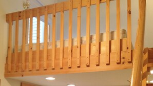 A room with a wooden loft bed, a door with a window, a fire extinguisher, and a framed picture on the wall. - Okemo Mt. Family Affordable 1st floor, village shuttle, walk to town, Dogs OK  (Ludlow)