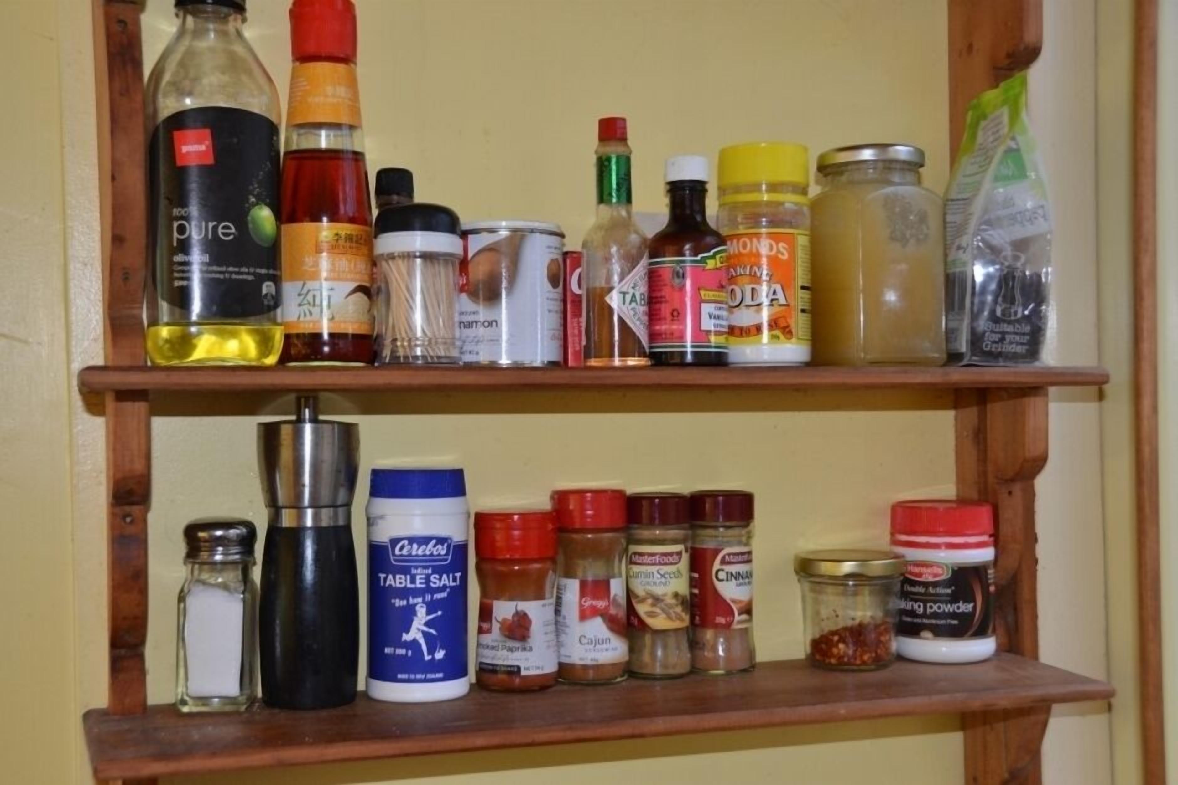 A shelf with various condiments and cooking ingredients.