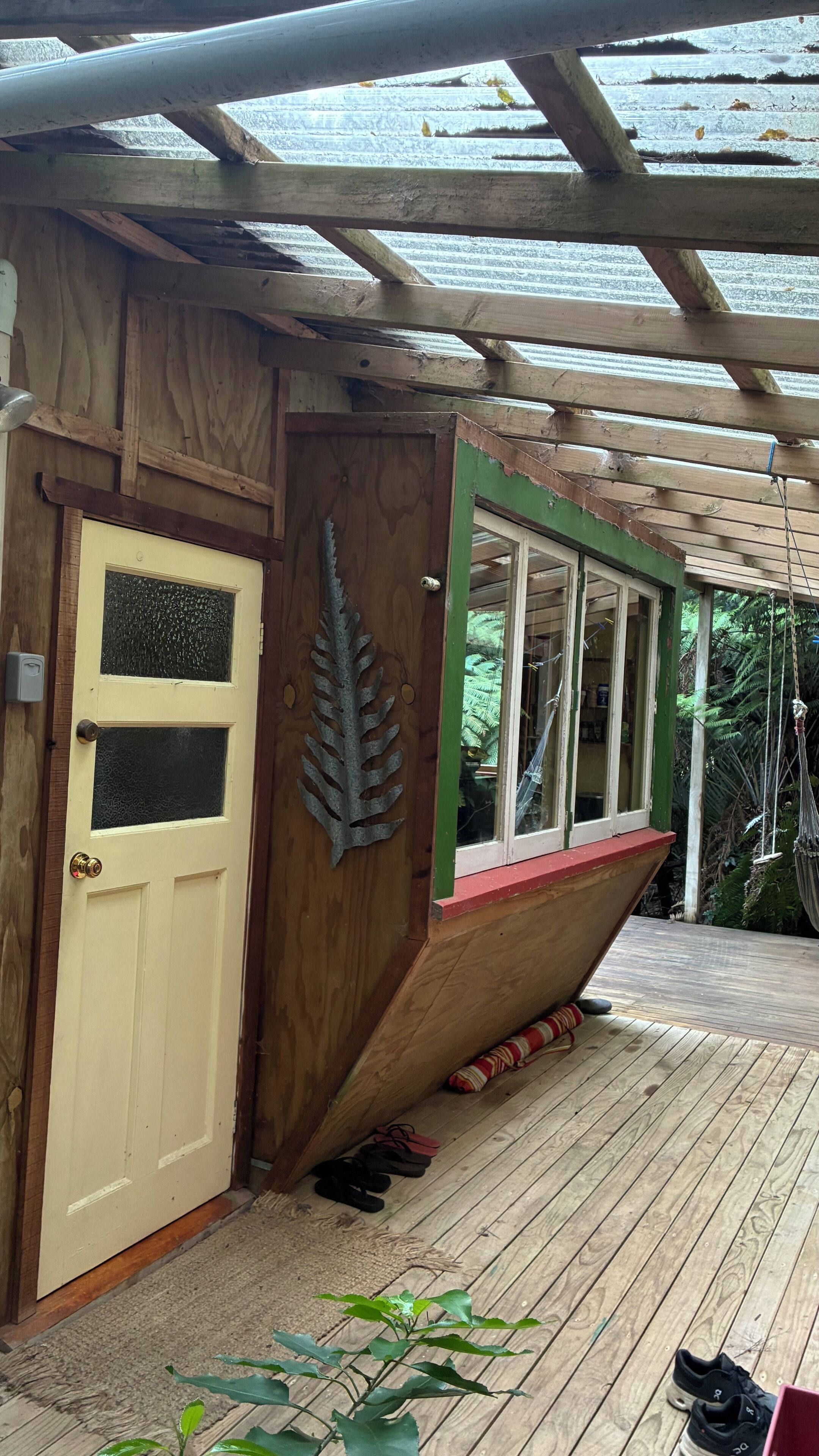 Un bâtiment en bois en forme de bateau, doté d’une porte, de fenêtres et d’un porche.