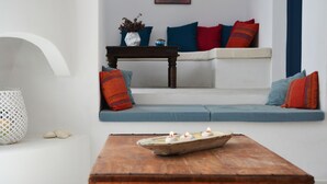 A living room with a sofa, a coffee table with candles, and a decorative vase. - Sea view house with swimming pool ISLA summer homes (Paros)
