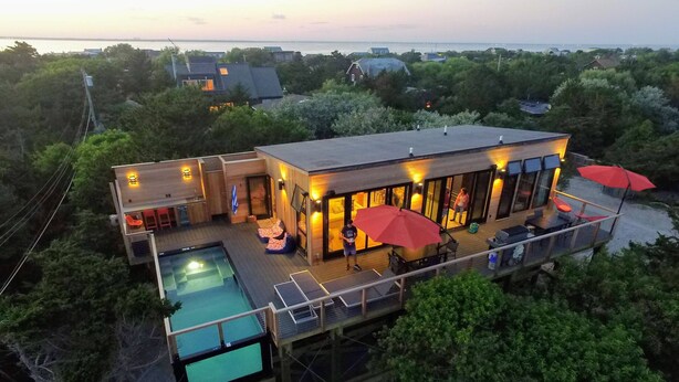 A modern house with a large deck, a swimming pool, and a view of the sea. - Windows on the Sea ★ Modern Pool & Beach Retreat ★ 100 ft to Beach ★ 2 Masters (Ocean Beach)