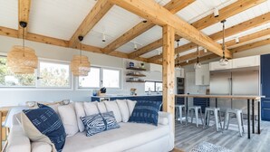 A modern kitchen with white cabinets, stainless steel appliances, and a wooden ceiling. - Windows on the Sea ★ Modern Pool & Beach Retreat ★ 100 ft to Beach ★ 2 Masters (Ocean Beach)