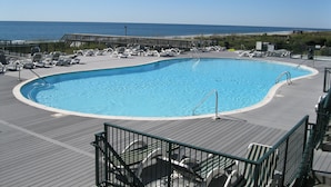 Une piscine avec des chaises longues et vue sur l’océan.