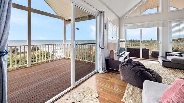 A spacious living area with a large sliding glass door leading to a wooden deck overlooking the ocean. - Flinders View Beach House (4Bed 2Bath) - Flinders View Beach House - Executive Holiday Home (Augusta)