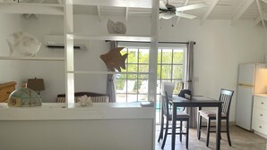 Una cocina moderna con comedor, ventanas amplias y un ventilador de techo.