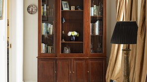 A room with a wooden bookcase, a chandelier, and a lamp. - A  stylish and sophisticated property centrally located in Howth (Howth)