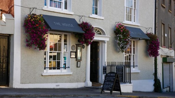 A building with a sign reading "THE HOUSE" and a blackboard with information. - A  stylish and sophisticated property centrally located in Howth (Howth)