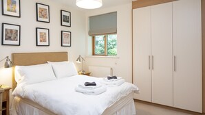 A bedroom with a bed, nightstands, a wardrobe, and framed artwork on the wall. - A  stylish and sophisticated property centrally located in Howth (Howth)