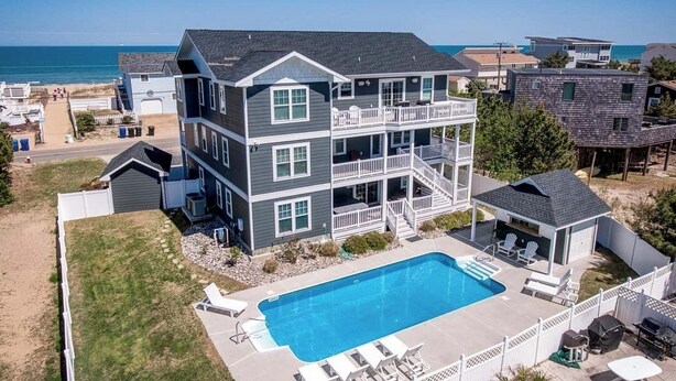 Une maison à plusieurs étages avec une piscine et un balcon.