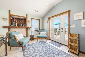 Un soggiorno con una poltrona blu, un tavolino in legno e un tappeto decorato.