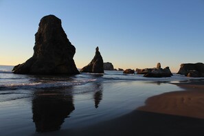 A beach with large rock formations and calm waves.