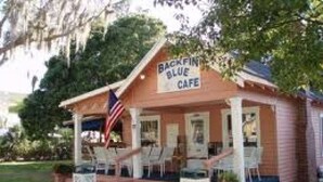 Un petit bâtiment sur lequel est accrochée une enseigne indiquant : « Backfin Blue Cafe ».
