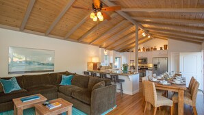 A spacious living area with a wooden ceiling, a sofa set, a dining table with chairs, and a kitchen in the background. - Los Arboles Ranch - Recreational Dream Near Hope Ranch (Santa Barbara)