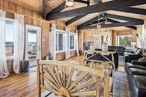 A wooden interior with a sofa, a table, and a chair.