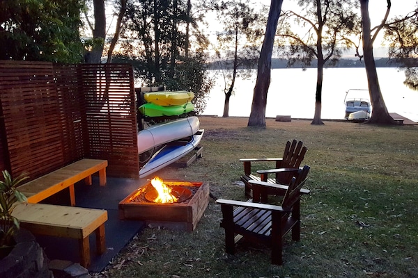 Relaxing fire pit by the lake along with canoes and kayaks for guests use