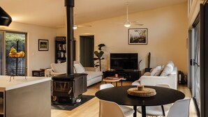 Una sala moderna con chimenea, sofá, televisión y comedor.