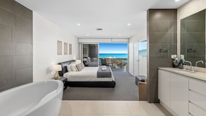 A modern bathroom with a large bathtub, a separate shower area, and a vanity with a mirror. - Beachfront #12 Beach Access, Pool, PetFriendly (Sapphire Beach)