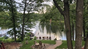 A lakeside deck with outdoor seating and a dock.