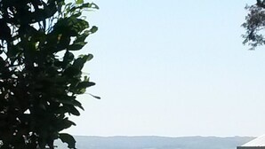A coastal landscape with a road, greenery, and a distant body of water. - Relax at Red Rocks - Pet friendly- WiFi - Winter special 4th night free (Cowes)