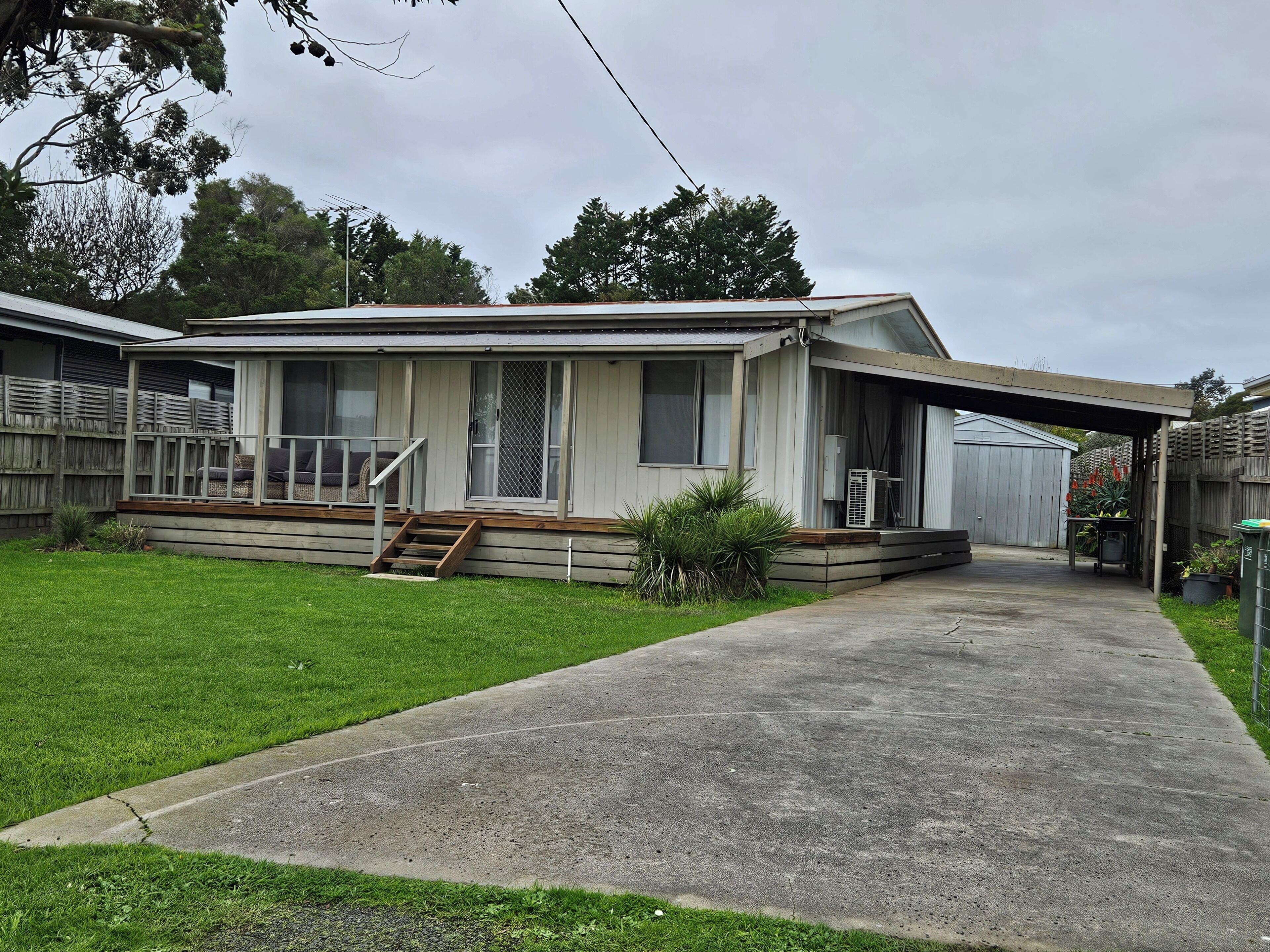 A single-story house with a covered porch, a front yard, and a garage.