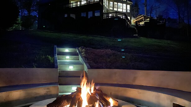 A fire pit with a house in the background. - Czarnecky Home - Waterfront Home in Deerfield Resort, Dock, Hot Tub, Firepit (La Follette)