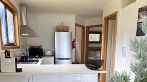 A modern kitchen with a central island, built-in appliances, and a cozy seating area with a wooden table and woven placemats. - WOW! No better location.
Beachfront, private & tranquil. Unwind and reconnect... (Seymour)