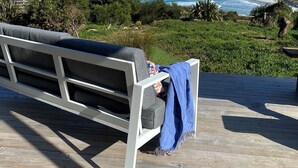 A wooden deck with a white bench overlooking a coastal landscape with mountains in the distance. - WOW! No better location.
Beachfront, private & tranquil. Unwind and reconnect... (Seymour)