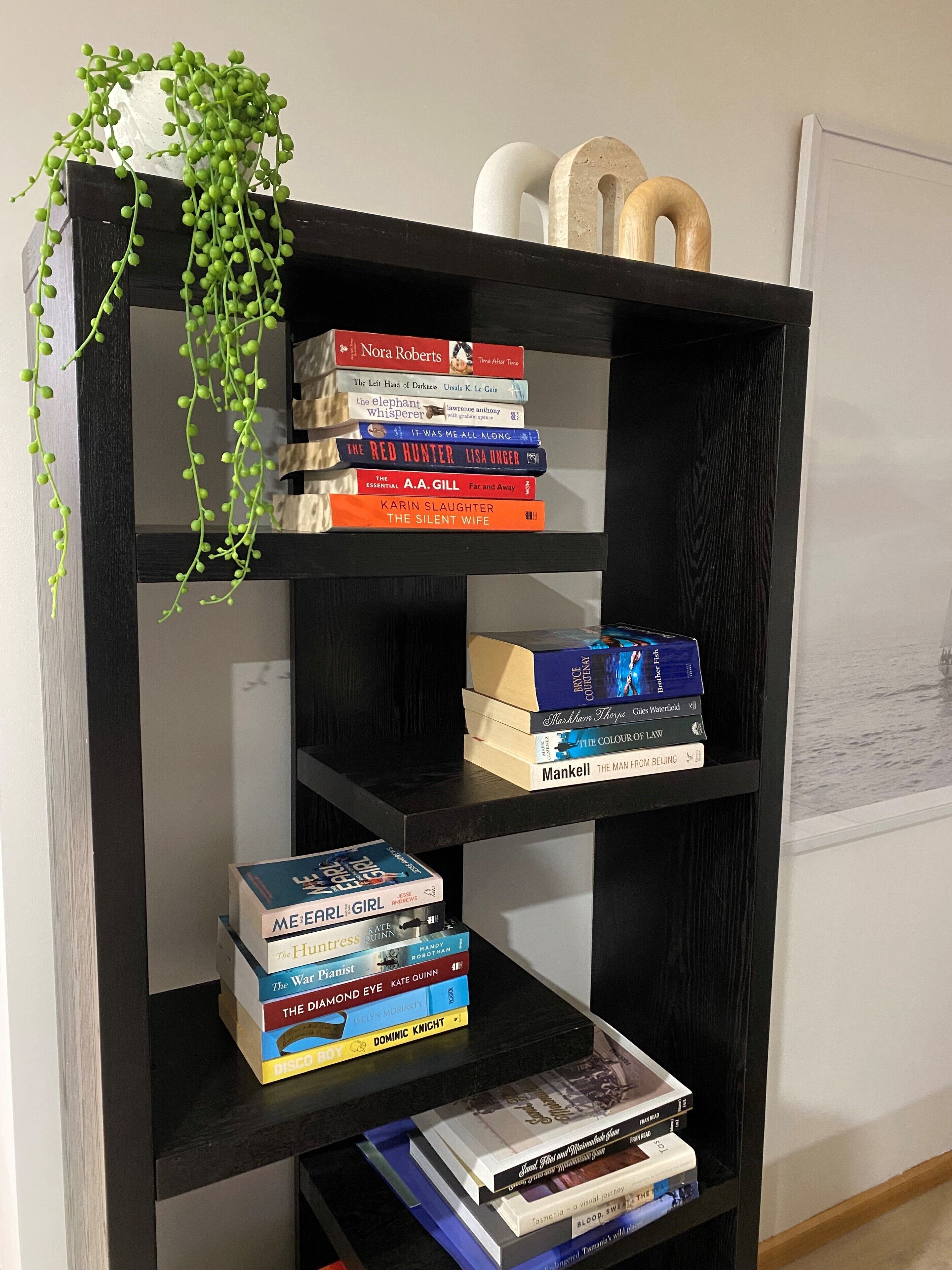 A bookshelf with various books and decorative items.