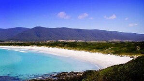 A coastal landscape with a beach, clear blue waters, and distant mountains. - WOW! No better location.
Beachfront, private & tranquil. Unwind and reconnect... (Seymour)