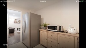 A kitchen with a stainless steel refrigerator, a microwave, a toaster, and a wooden cabinet. - Private Guest house close to Disneyland & Little Saigon Mall (Santa Ana)