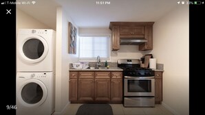 A modern kitchen with a double oven, stainless steel appliances, and wooden cabinets. - Private Guest house close to Disneyland & Little Saigon Mall (Santa Ana)