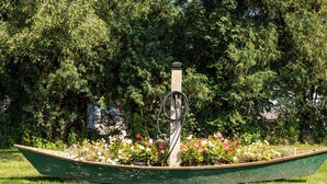 A green boat-shaped planter with flowers and a metal structure in a park. - Private Beach & Pier Lake Front w/ Fireplace on Lake Como - Walk to Mars Resort! (Lake Geneva)