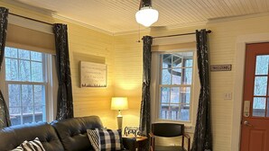 A cozy living room with a leather sofa, a wooden coffee table, and a ceiling fan.