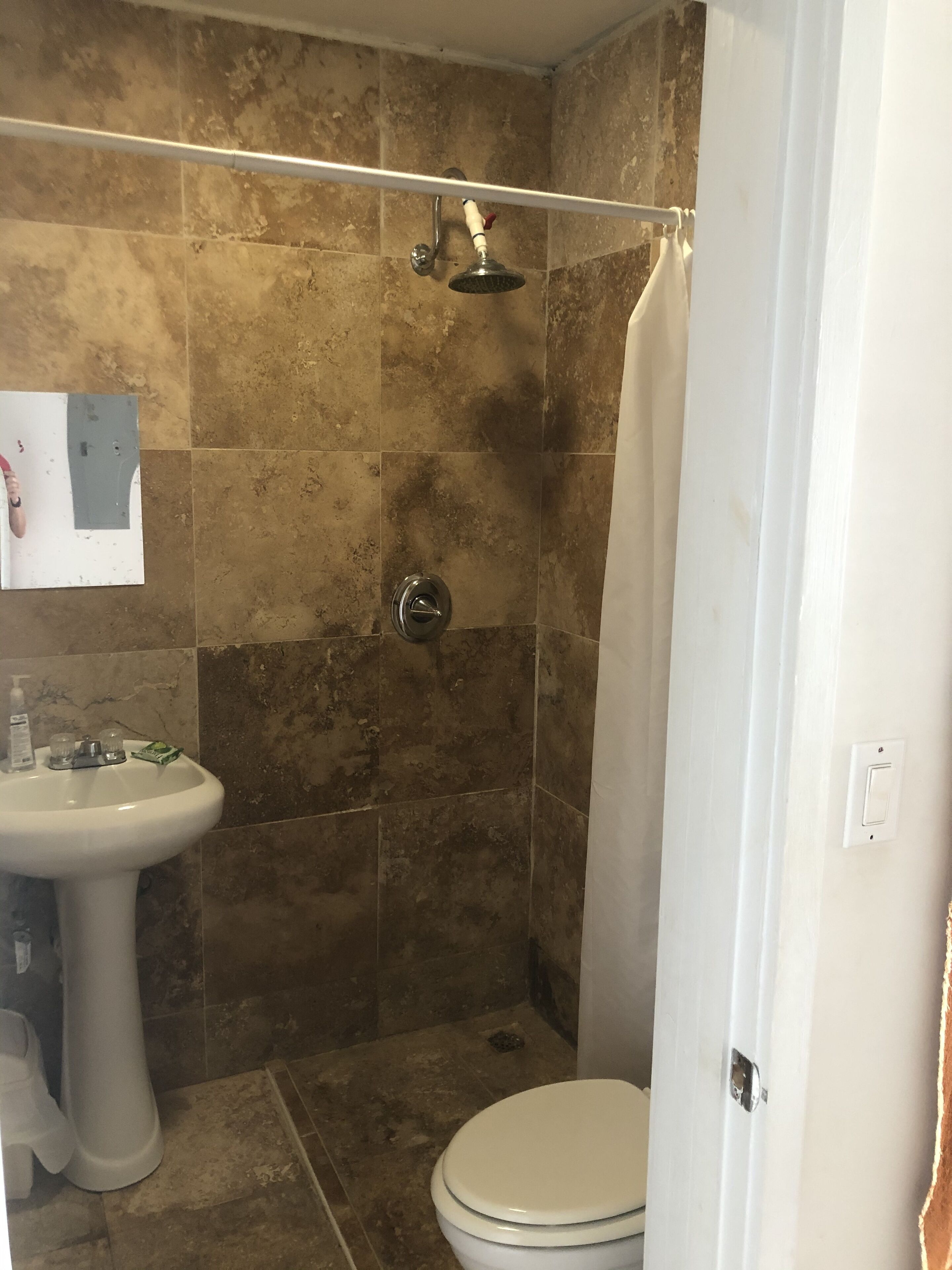 Un baño con ducha, inodoro y lavamanos.
