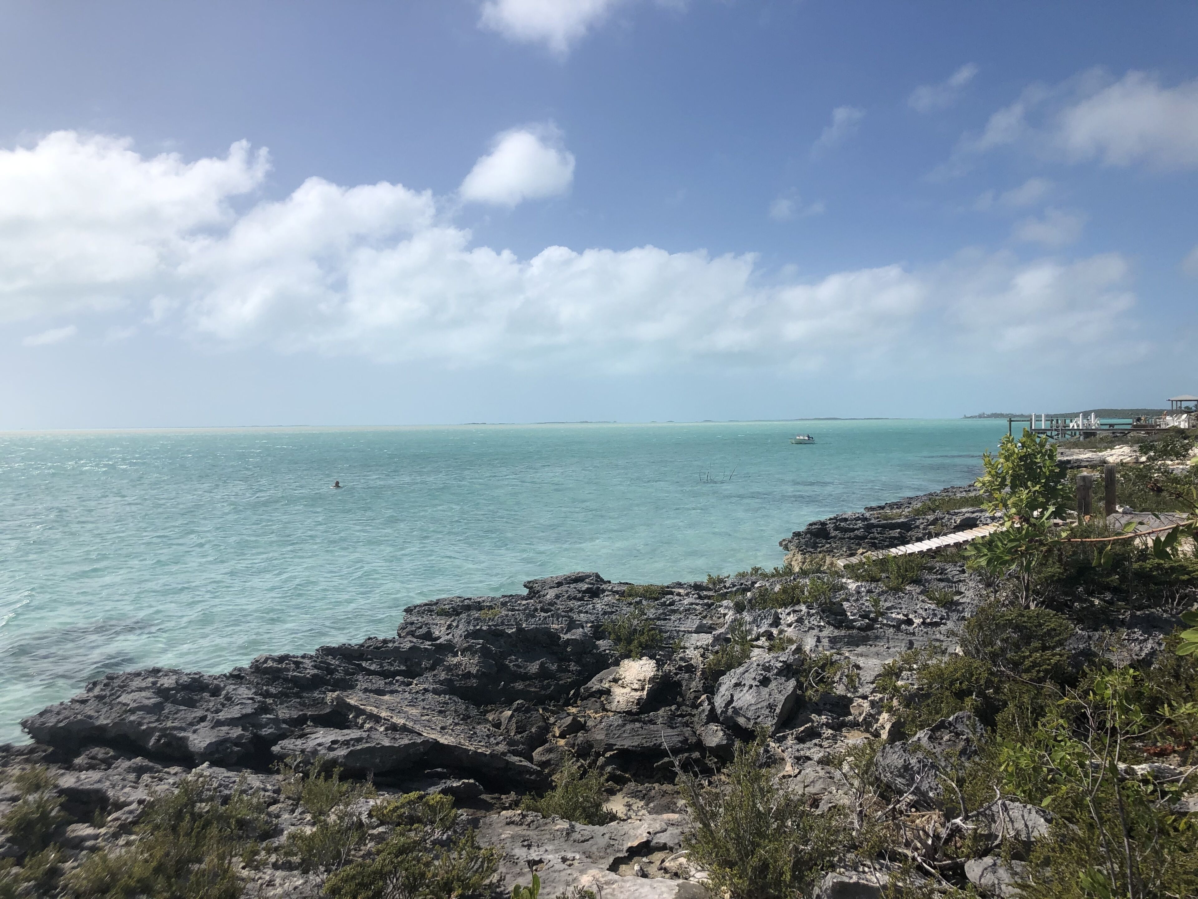 A coastal landscape with rocky terrain and a clear view of the sea.