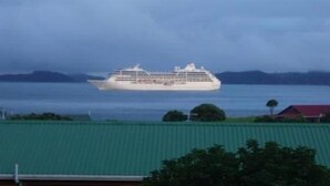 A cruise ship in the distance with a green-roofed building in the foreground. - Teaghlach: Tapeka / Russell Holiday Home (Tapeka Point (Russell))