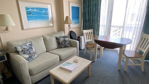 A hotel room with a sofa, a coffee table, a dining table with chairs, and two framed pictures on the wall. - Beautiful 9th floor OceanView Studio Condo  - Pool is OPEN! (Daytona Beach)