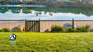 A residential area with houses, a pond, and a fence. - Holiday Home with Private Beach & Stunning Views! (Encounter Bay)