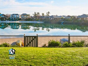 A residential area with houses, a pond, and a fence. - Holiday Home with Private Beach & Stunning Views! (Encounter Bay)