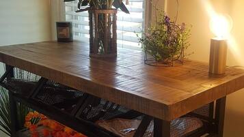 Une table en bois, ornée d’un vase de fleurs et d’une bougie.