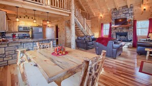 Eine geräumige Holzhütte mit Essbereich, Küche und Wohnzimmer.