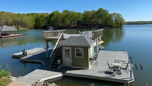 A dock with a small cabin, a covered seating area, and a boat ramp. - Charming waterfront home, with central location to area marinas, plus Super Dock (Moneta)