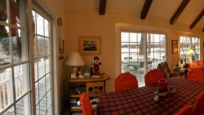 A cozy living room with a fireplace, a television, and a dining area with a red and black checkered tablecloth. - Charming waterfront home, with central location to area marinas, plus Super Dock (Moneta)