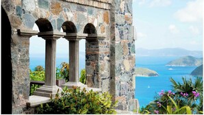 Una estructura de piedra con columnas y arcos que domina una vista costera.