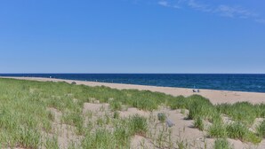 A beach with sand dunes and a clear blue sky.