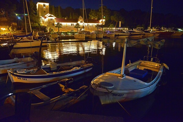 A marina at night with several boats docked.